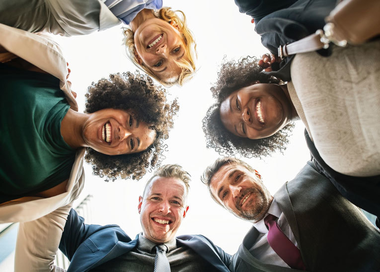 Engaged employees smiling in huddle image