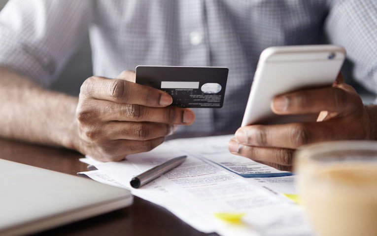 Man entering bank card details into phone image