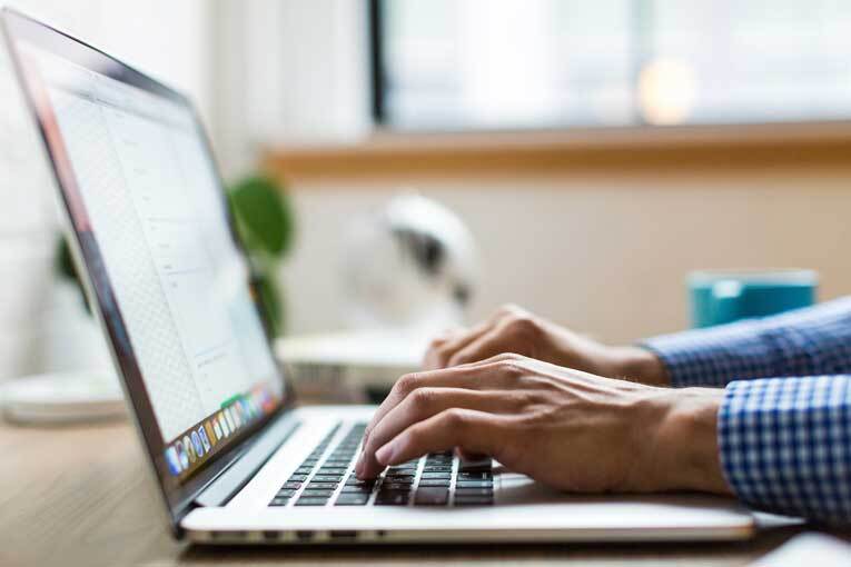 Man writing a marketing plan on laptop image