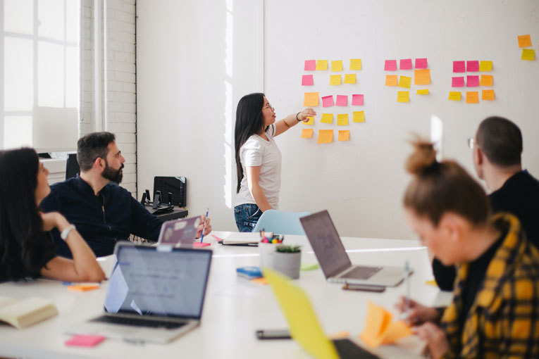 People in a meeting room listening to a presentation image