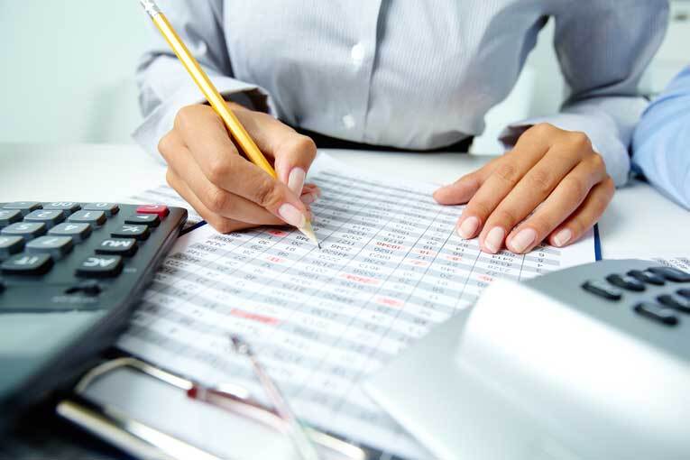 Woman calculating vat at office desk image