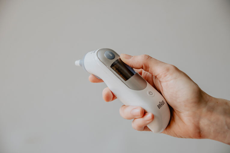 Woman holding digital thermometer image