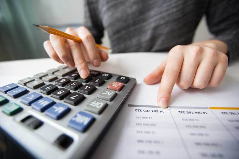 Woman typing on calculator doing tax return image